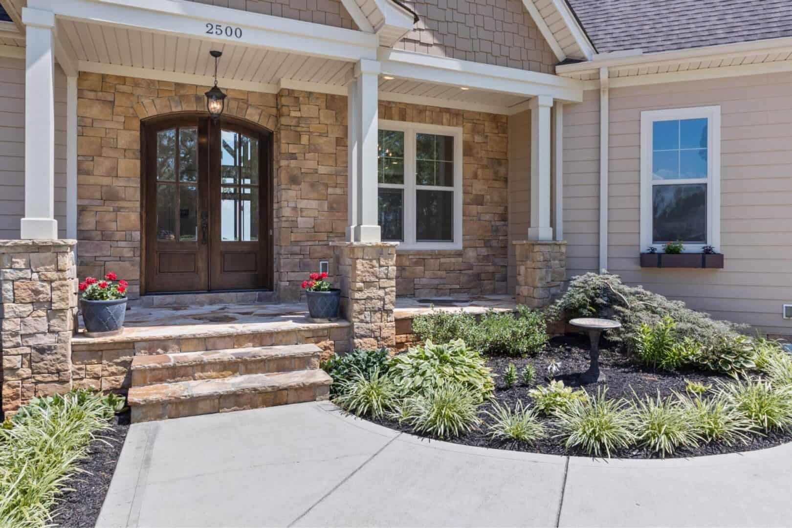 The front of a home with stone steps and landscaping.