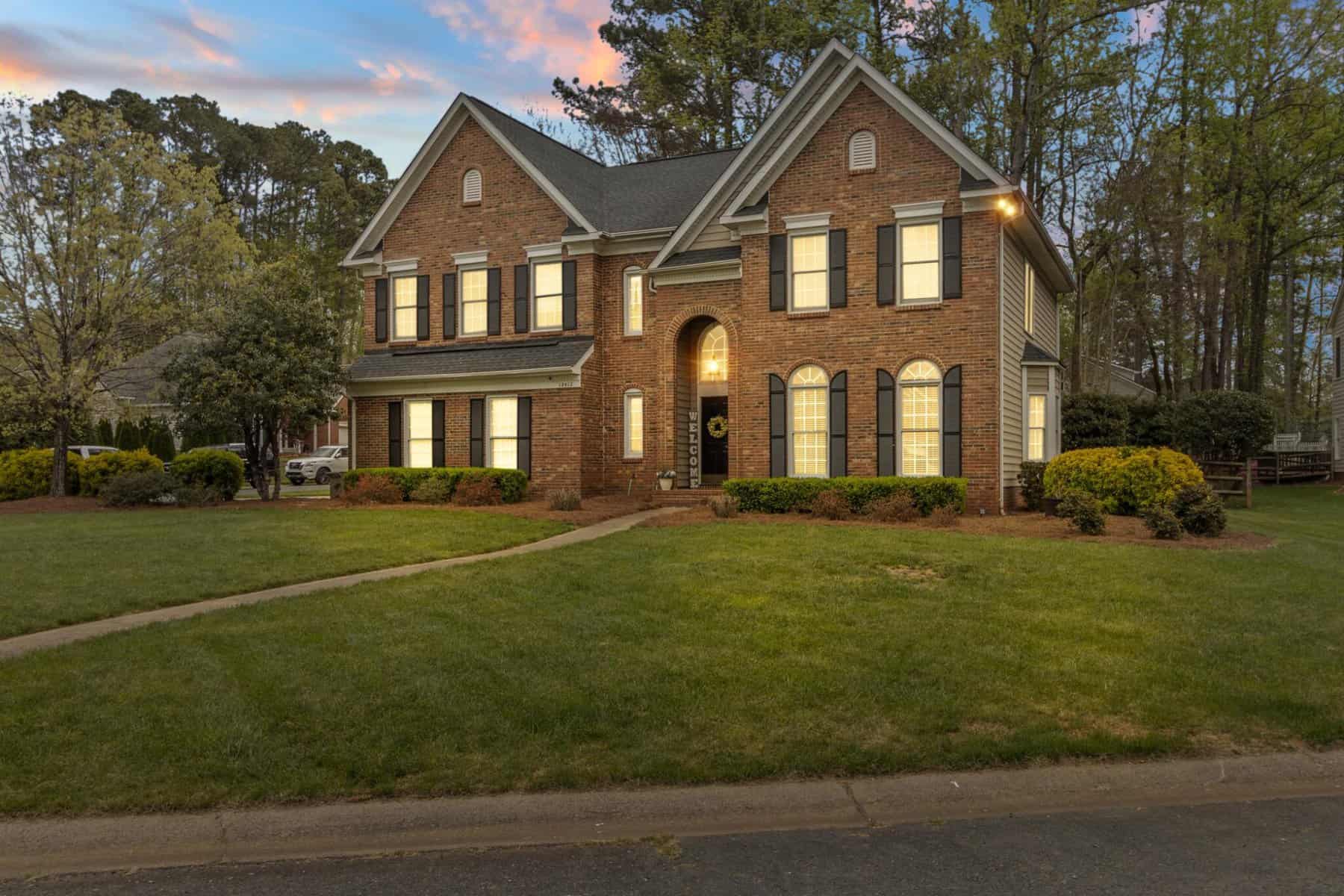 A brick home in the suburbs at dusk.