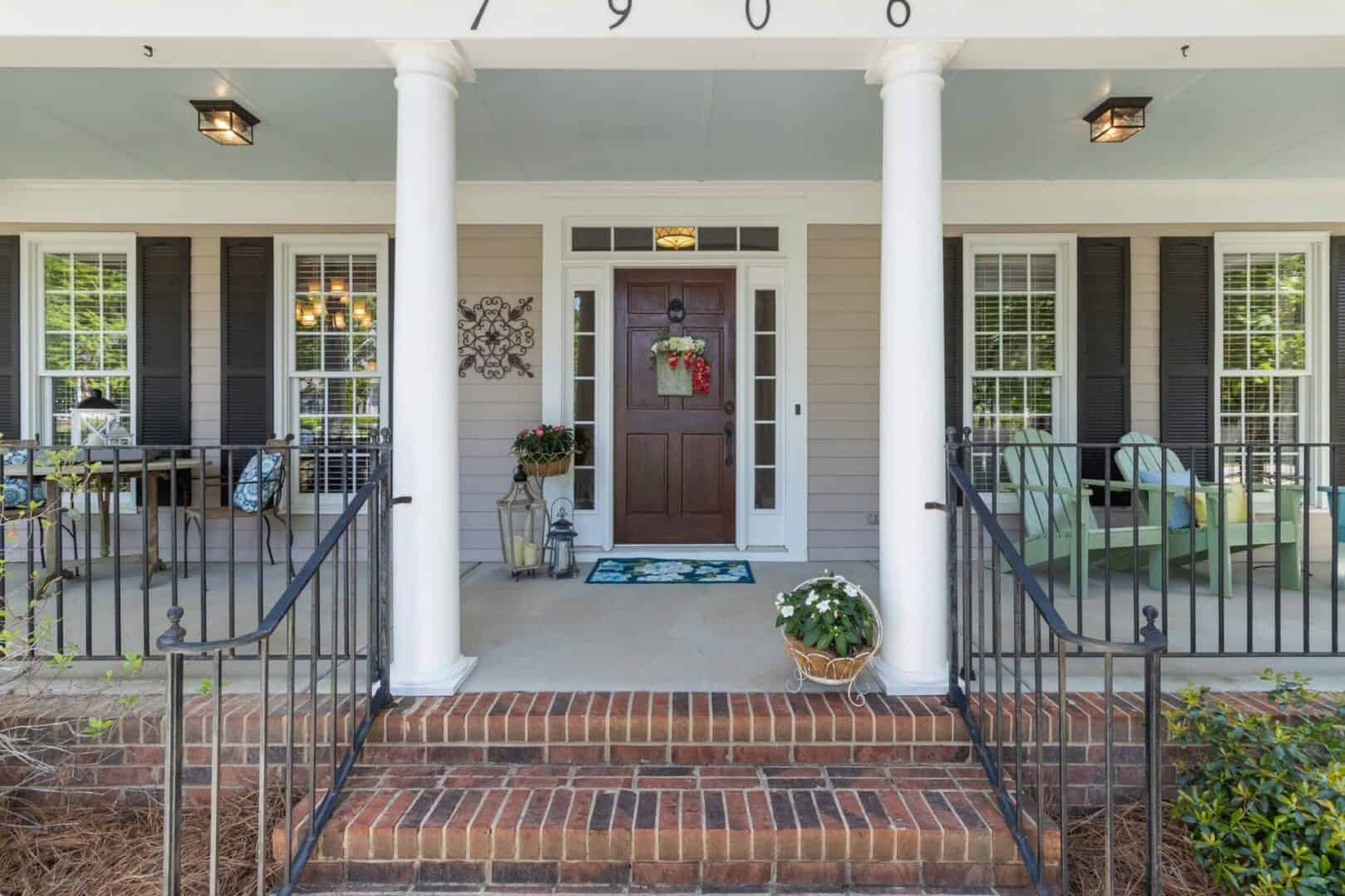 The front porch of a home with black railings.