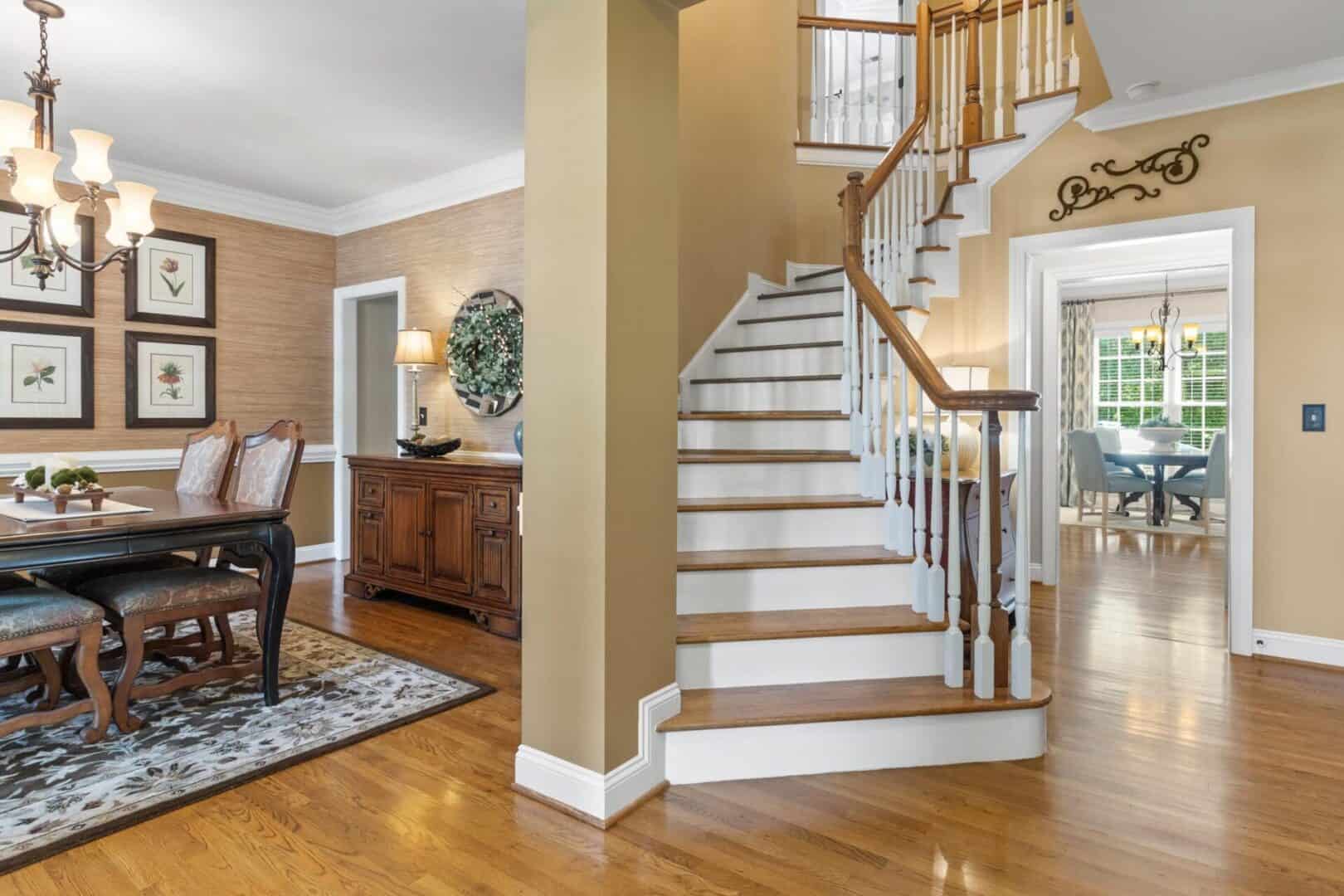 A dining room with hardwood floors and a staircase.