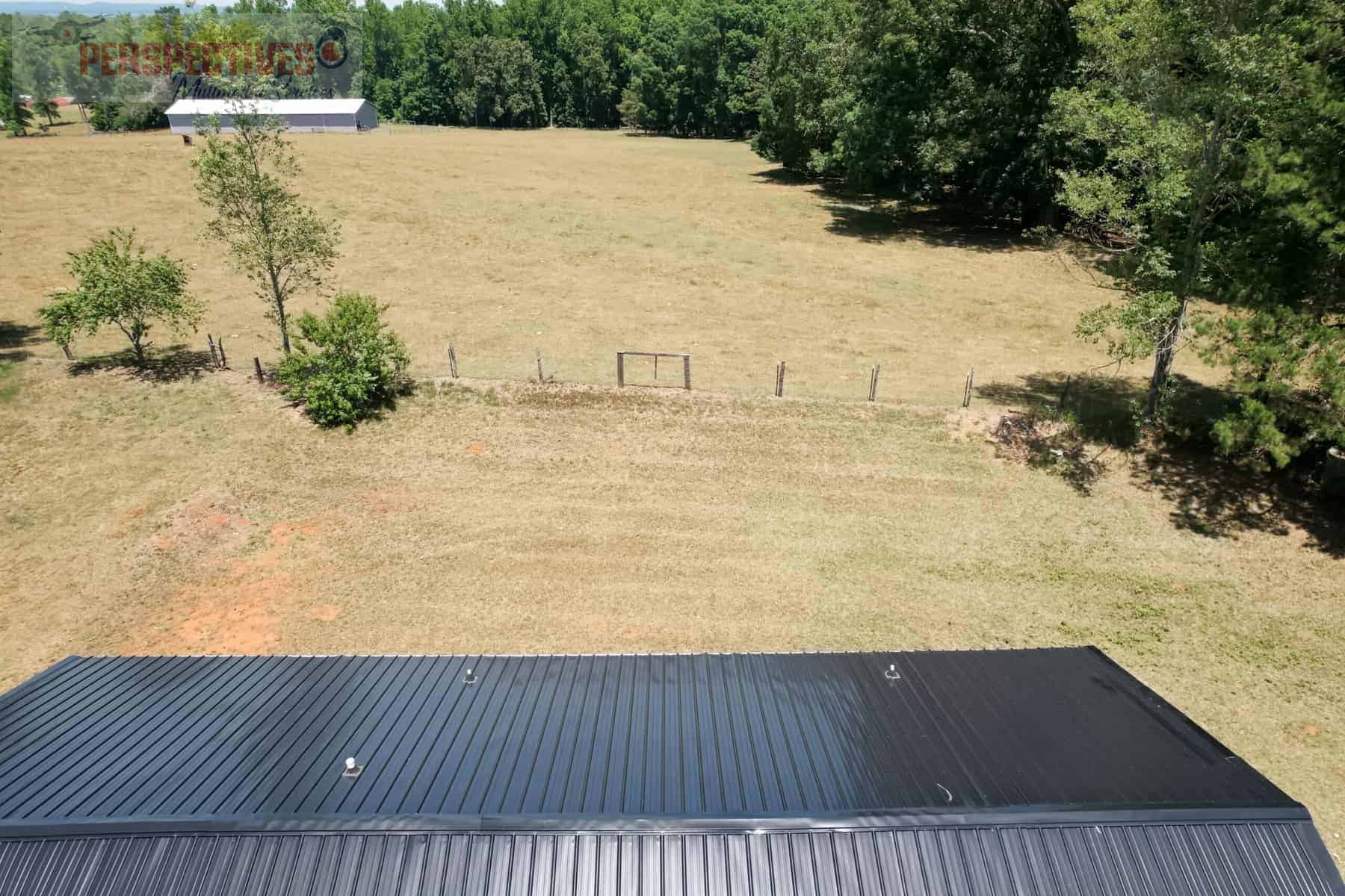 An aerial view of a black metal roof in a field.