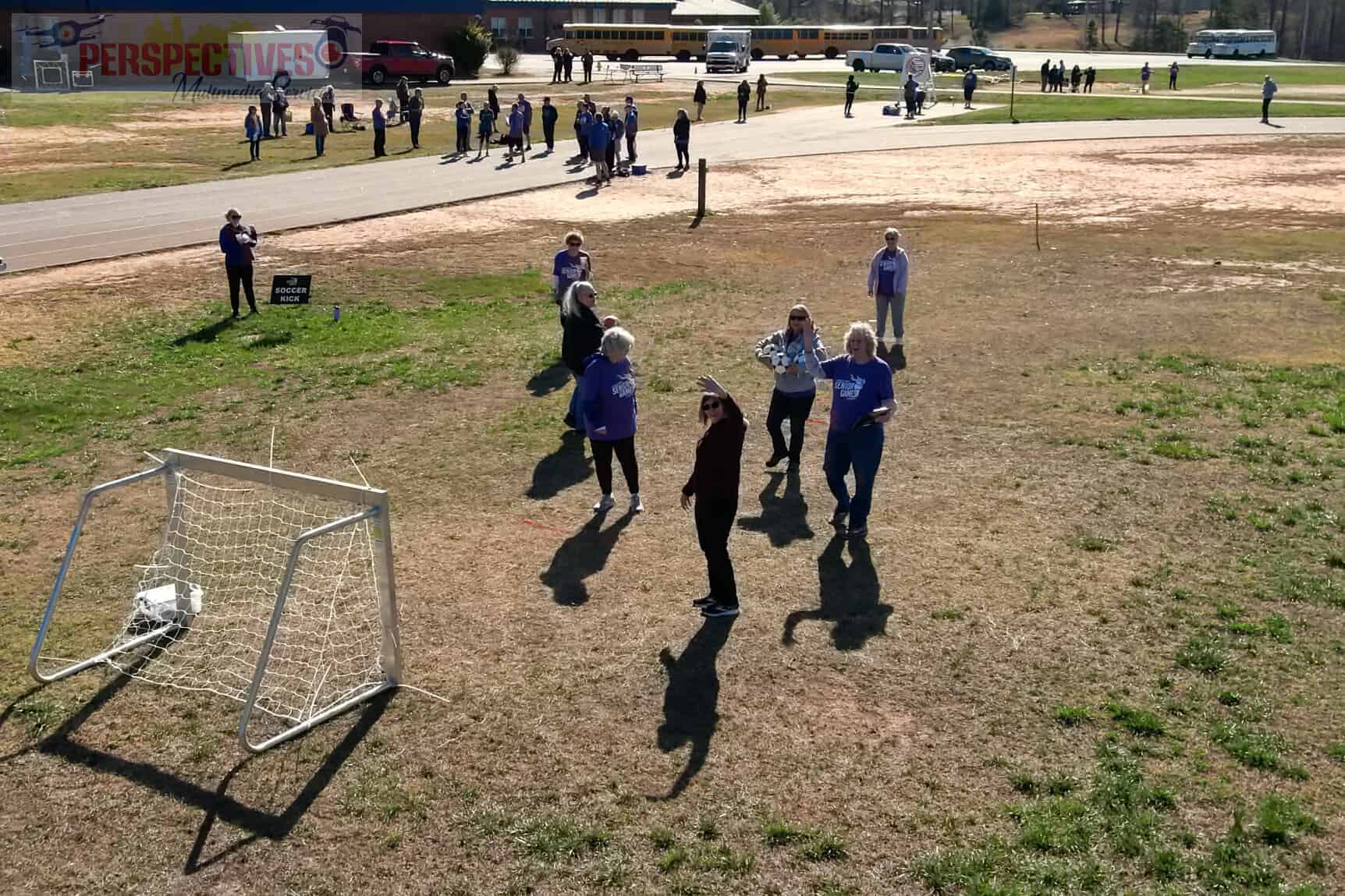 A group of people standing around a soccer goal.