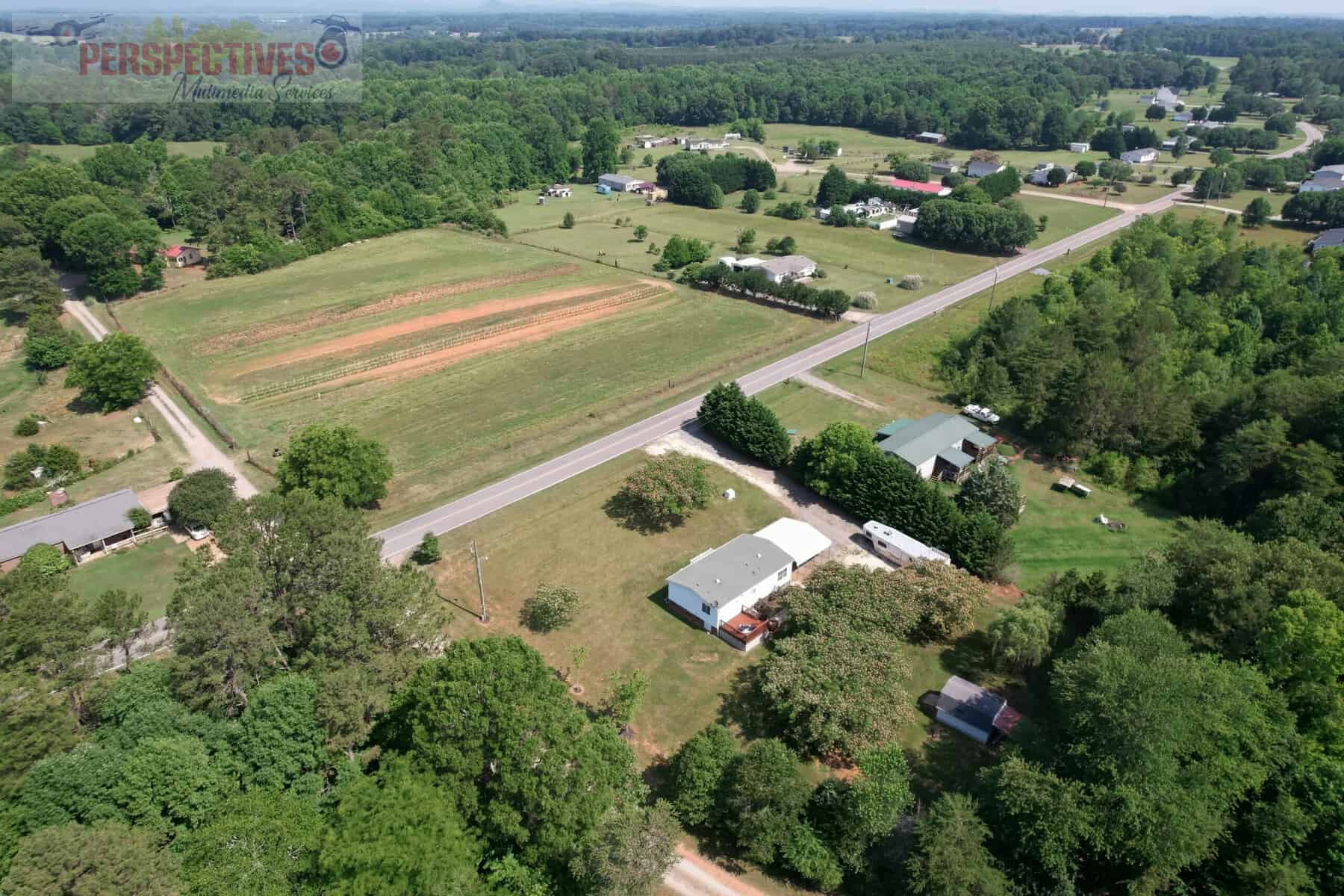 An aerial view of a farm and woods.