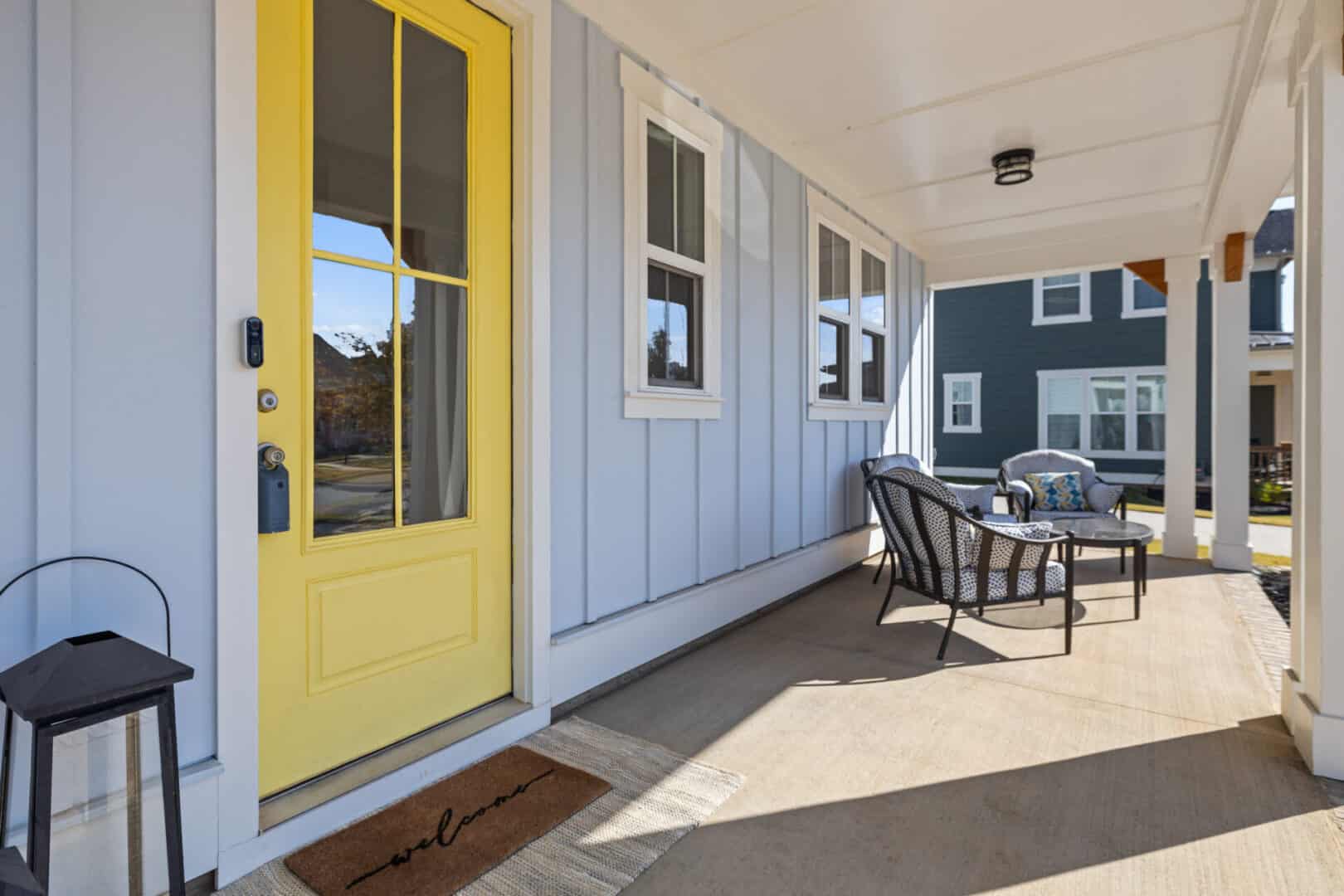 The front porch of a home with a yellow door.