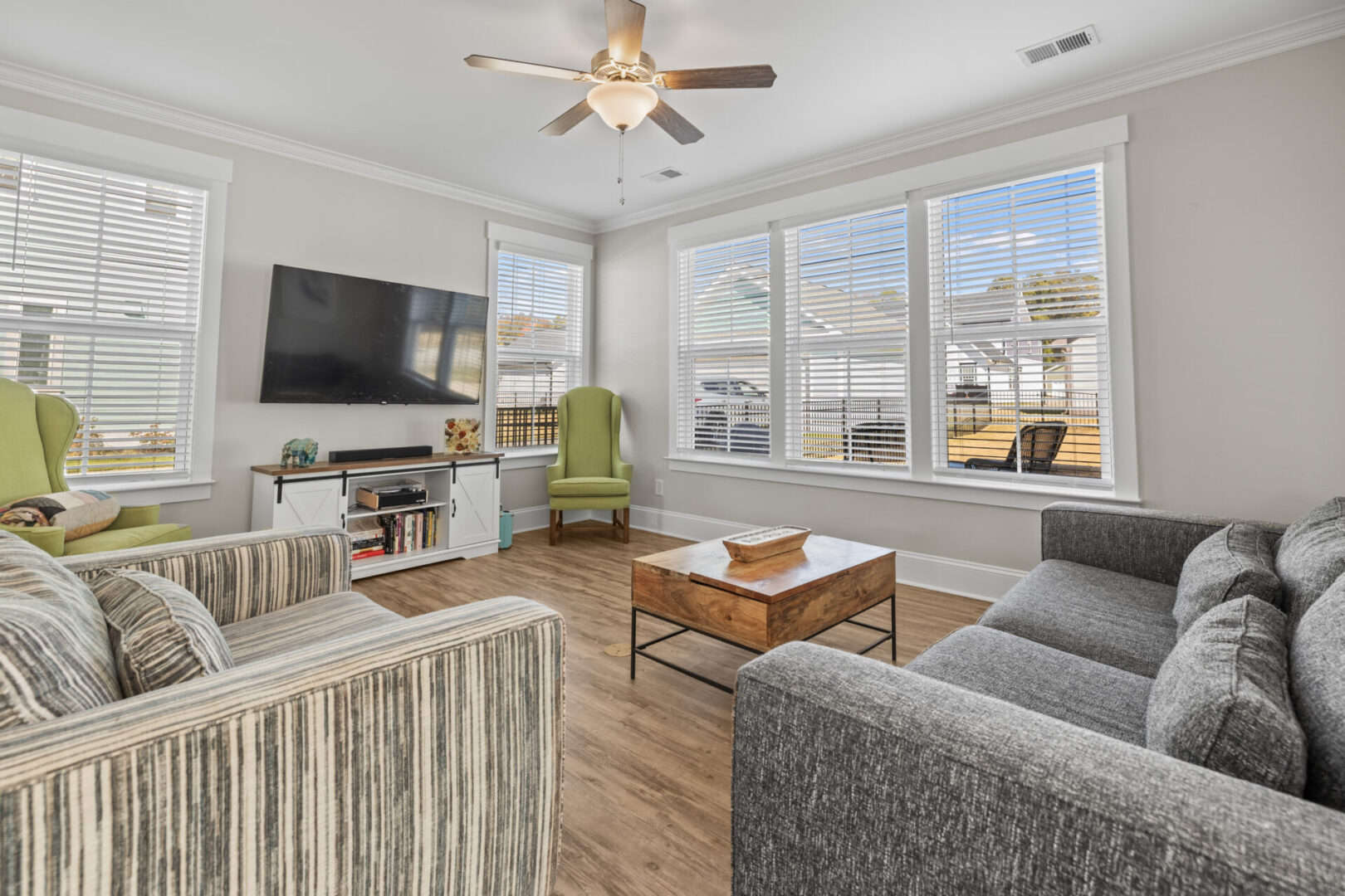 A living room with hardwood floors and a ceiling fan.