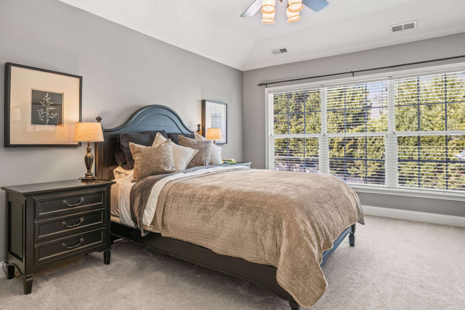 A bedroom with a bed and a ceiling fan.