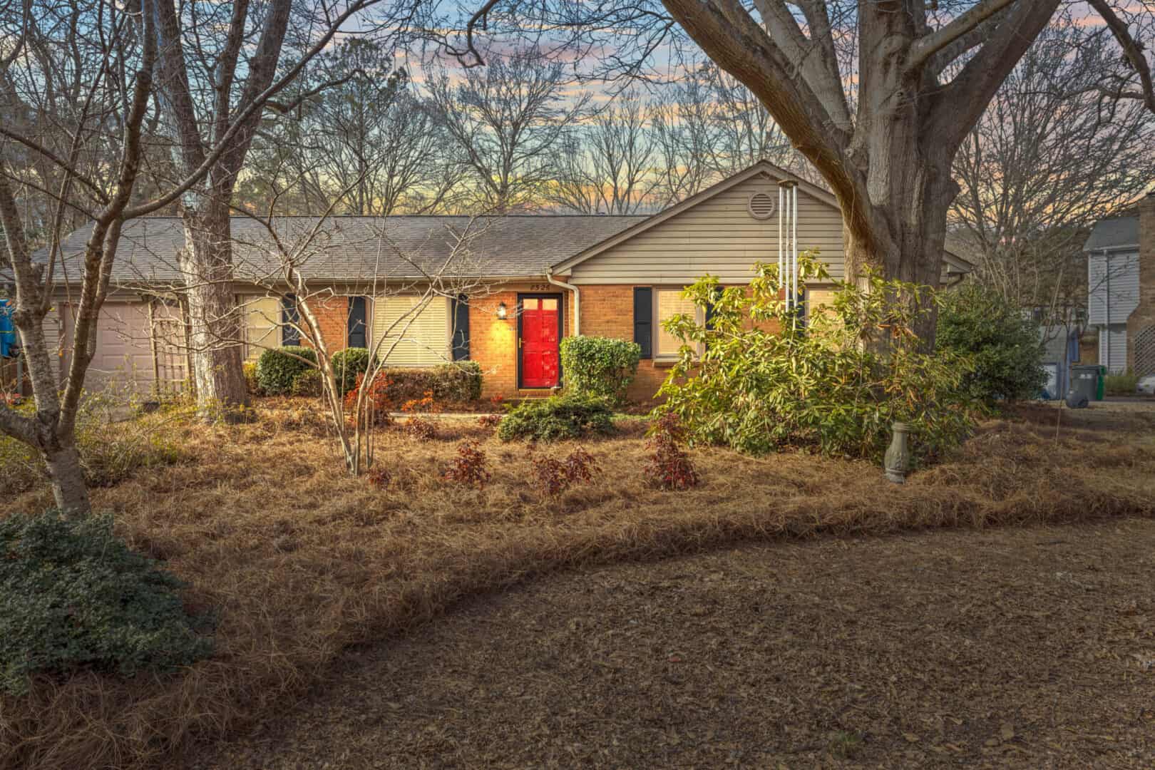 A home in the woods with a red door.