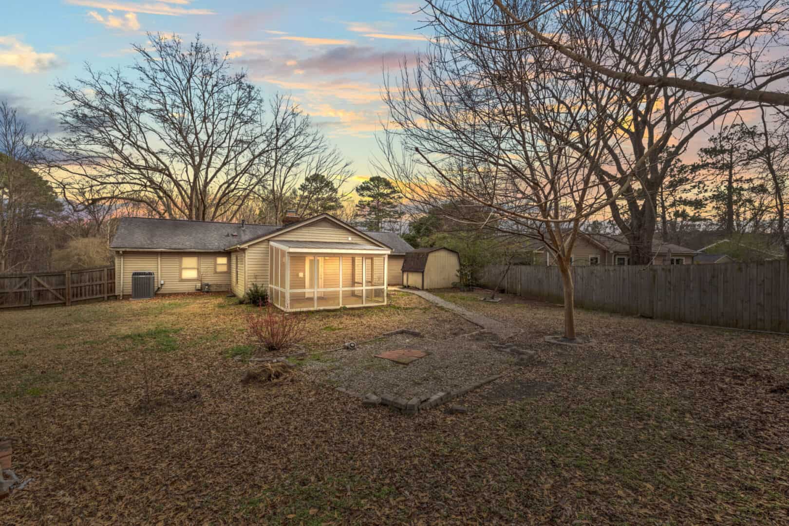 A house with a fenced yard and a gazebo.