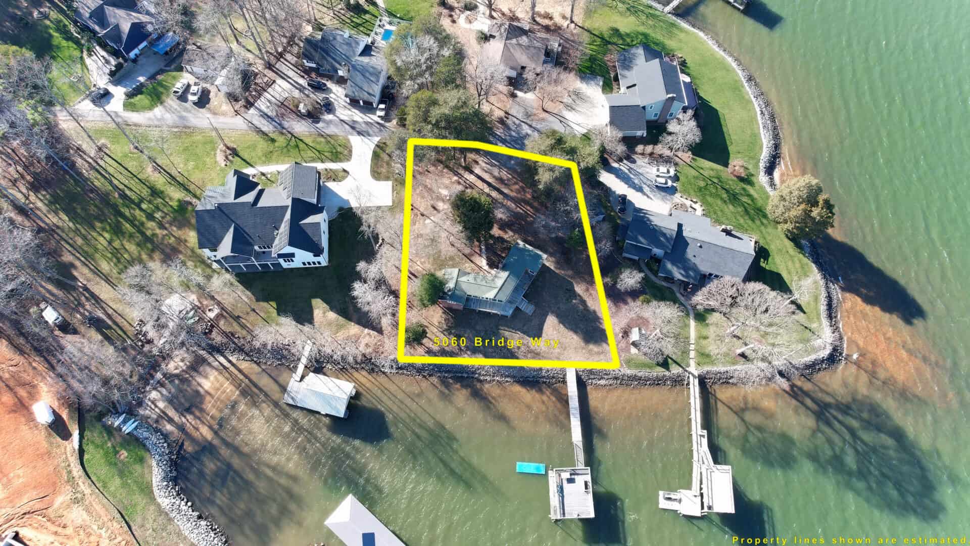 An aerial view of a house with a dock on the water.